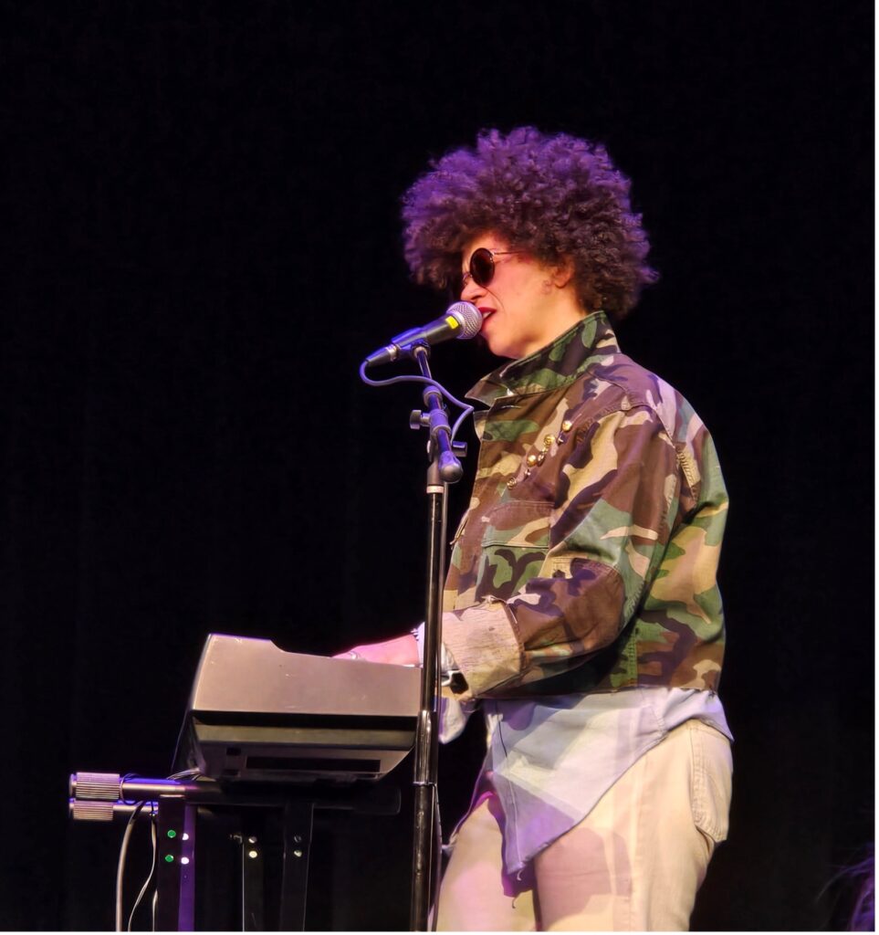 Woman singer on stage playing her keyboard